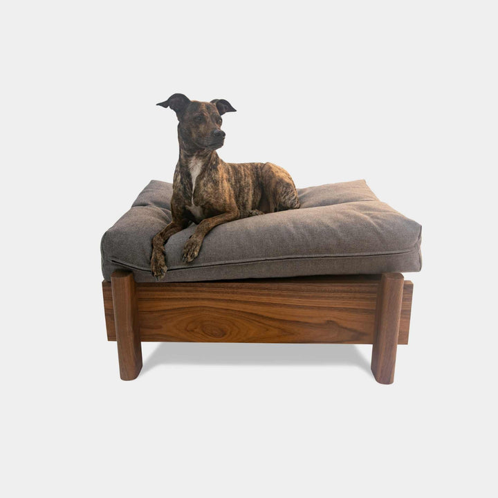 This EARL handmade dog bed has a solid wood base with a hidden drawer, and a custom detachable cushion upholstered in Sunbrella Blend Sand. We offer various fabrics and customers own fabric is encouraged as well. The base can be made in walnut, white oak, or ebonized oak and custom sizing is also available.