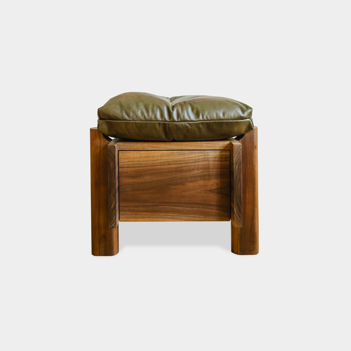 The LAPILO Ottoman by Earl Home is a stylish, handmade piece featuring a green cushioned top and offers storage seating against a white background.