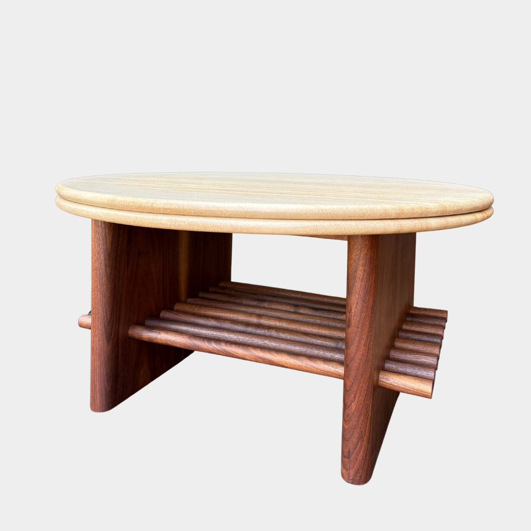 The sandstone circular coffee table, featuring a refined double bullnose edge, showcases the stone’s natural beauty while adding a soft, sculpted touch. 
Supporting this stunning round top is a sleek and sophisticated solid walnut base, meticulously crafted for both durability and style. 