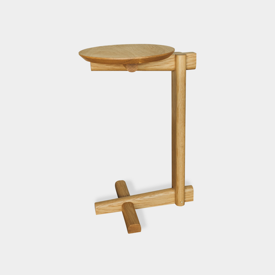 The White Oak MEDIA Side Table by Earl Home is a beautifully crafted nesting table featuring a solid wood construction with a round top and a custom-designed T-shaped base.