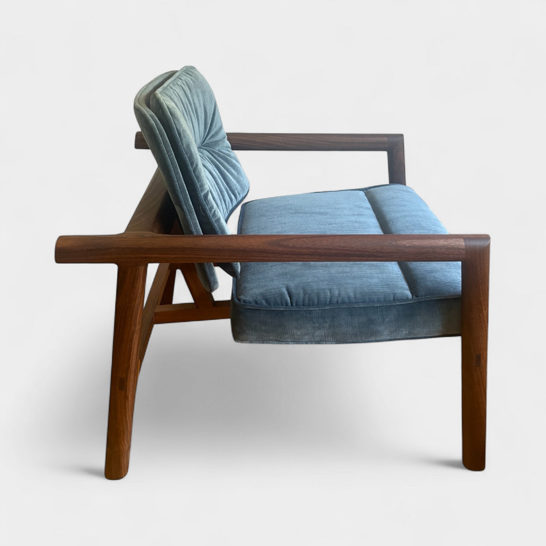 Blue cushioned MORESBY Lounge chair with solid wood walnut frame. Custom upholstery available and in stock in walnut or white oak. 