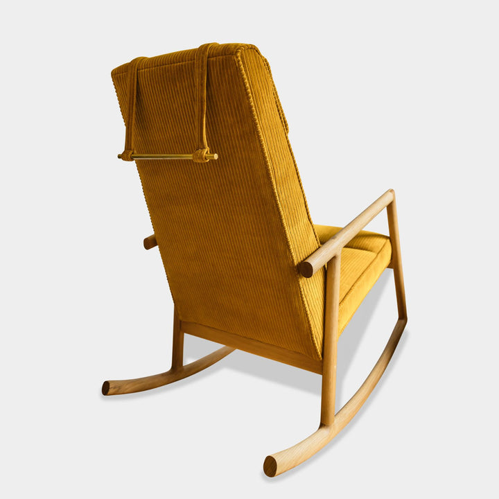 Side view of the MORESBY Rocker by Earl Home. This handmade wooden rocking chair features white oak solid wood construction, kvdrat phlox corduroy custom upholstered seat, and an attached headrest.