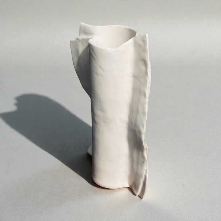 White ivory beige ceramic vase on a light gray background