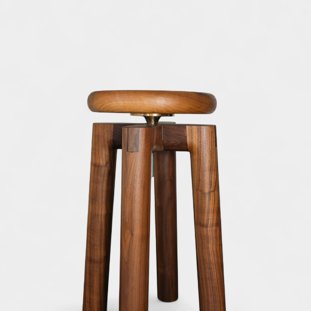 Solid walnut wood stool with a round seat that swivel screws up and down 5". Available in white oak, ebonized oak, white oak, and ash. 