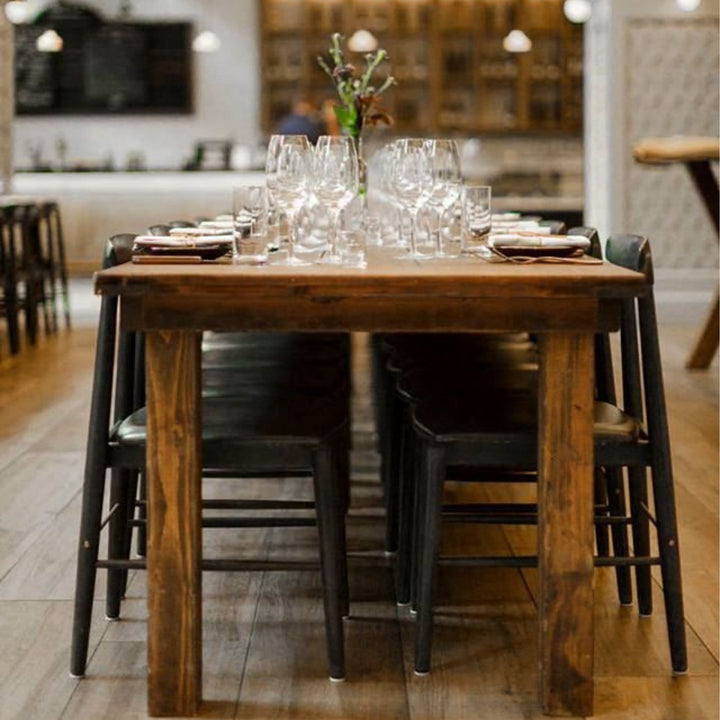 The Earl Home SABLE Dining Chair features a hand-made, bespoke charcoal fumed walnut wooden design with a curved backrest and four legs. Its flat seat exemplifies minimalist elegance, crafted from solid wood for lasting durability. Black leather upholstery.