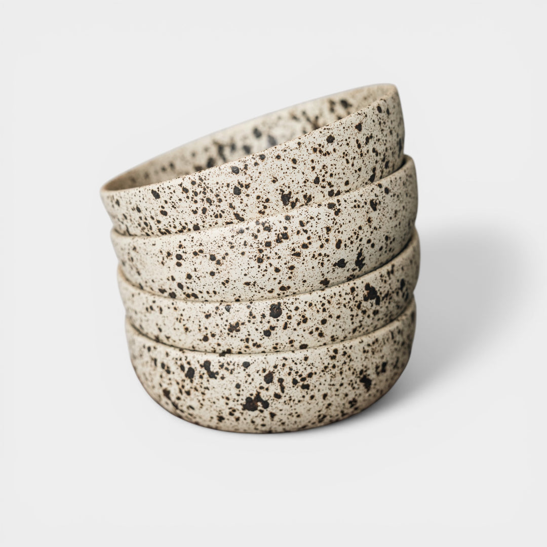Stack of speckled ceramic bowls on a light background