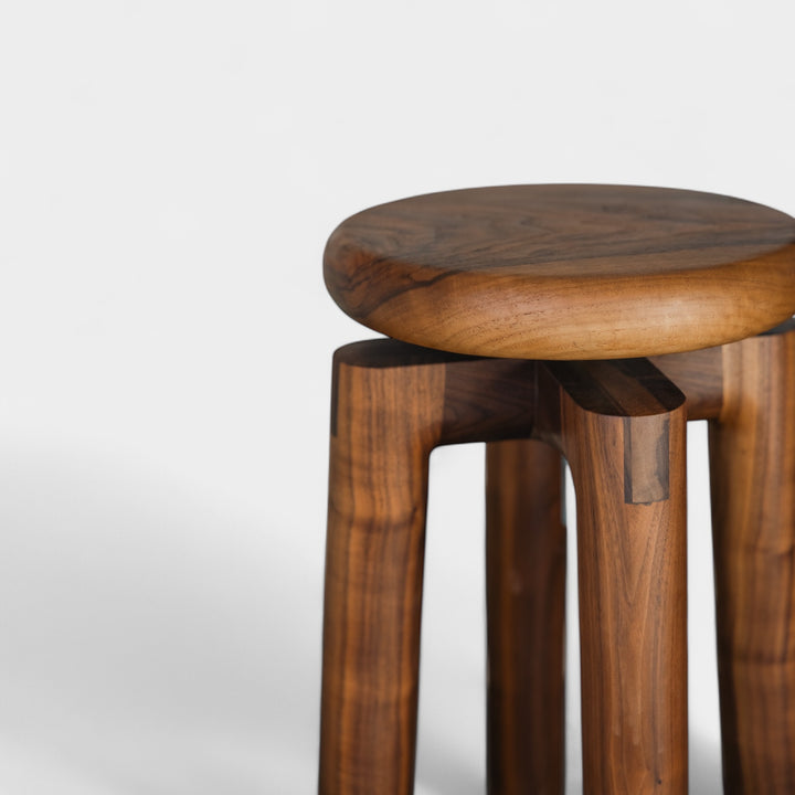 Solid walnut wood stool with a round seat that swivel screws up and down 5". Available in white oak, ebonized oak, white oak, and ash.