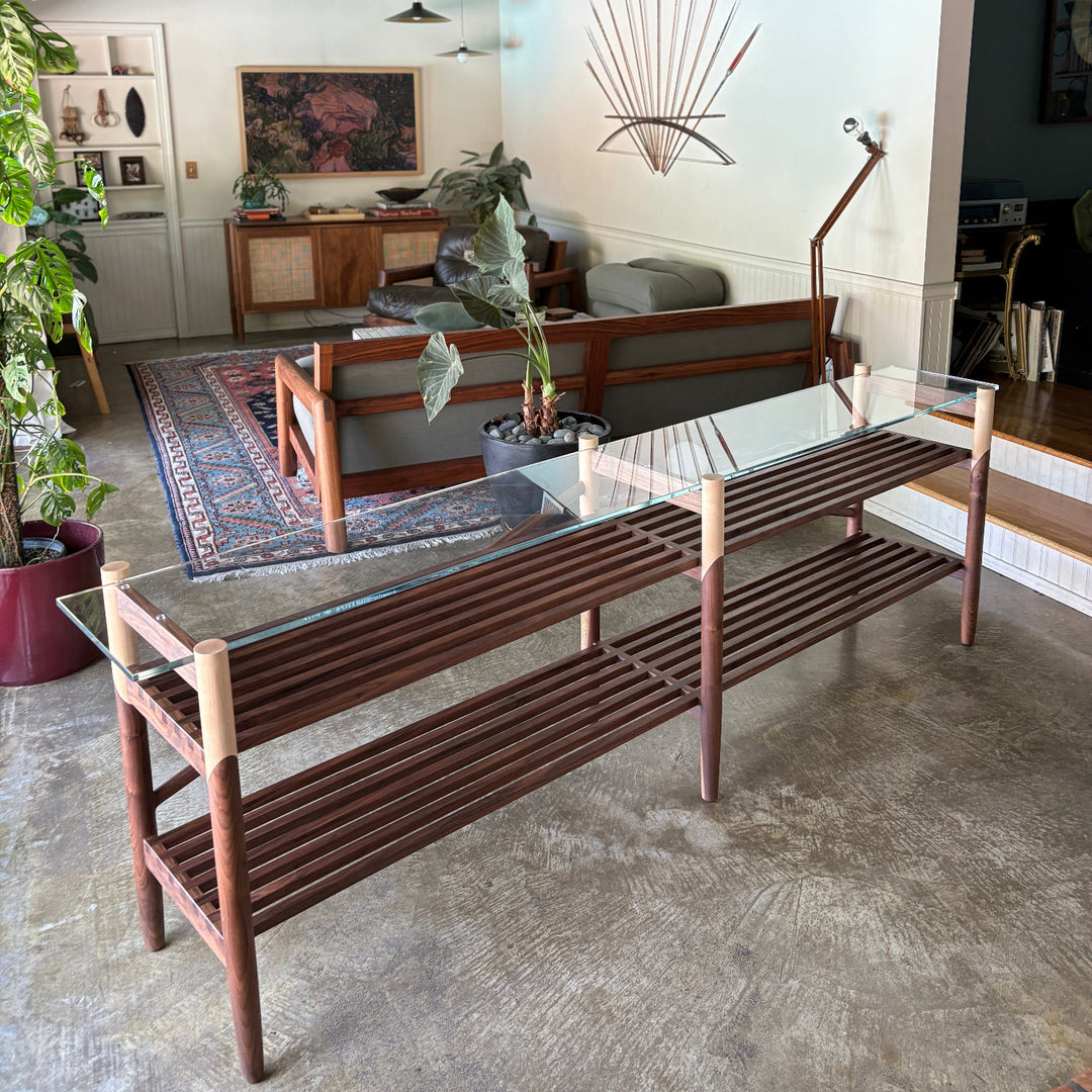 Hand-turned solid wood base. Polished clear tempered glass top. Fine brass accents. Handmade or hand crafted furniture made of Walnut and Maple.