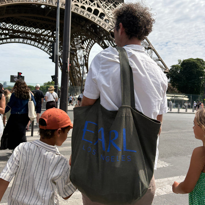 People near the Eiffel Tower with a person wearing a shirt with &