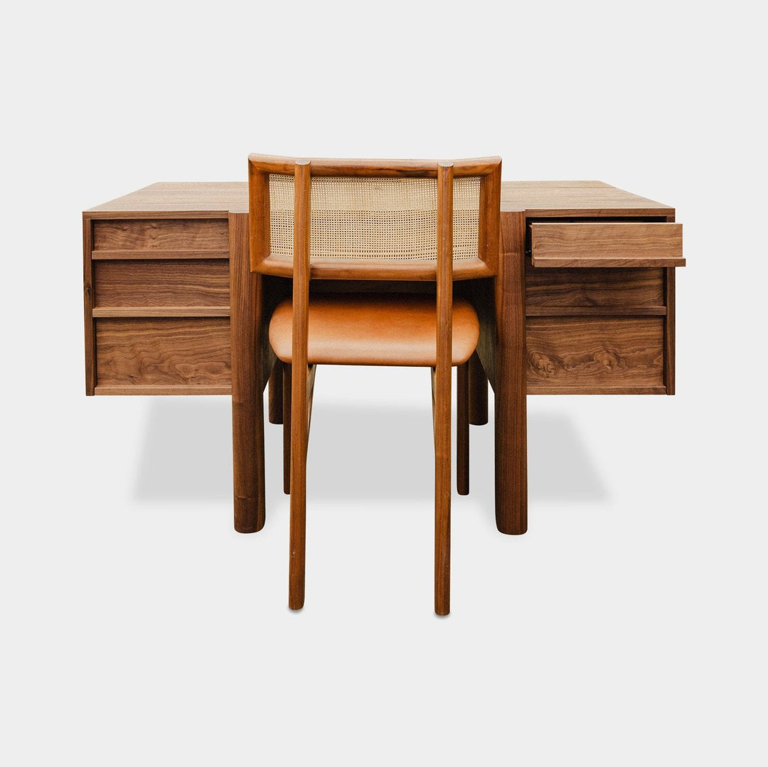 The LAPILO Desk by Earl Home is a handmade wooden piece with minimalist design, reminiscent of a classic tanker desk, featuring four side drawers and straight, sturdy legs.