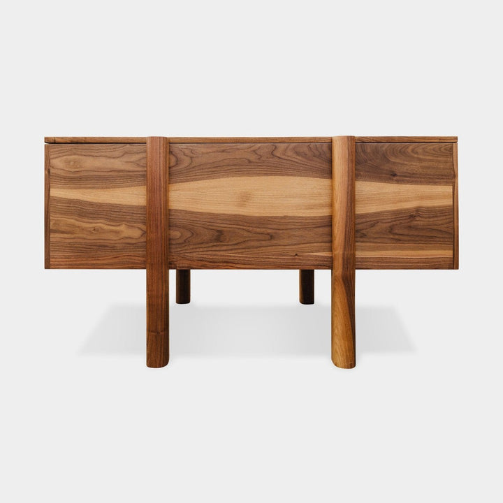 The LAPILO Desk by Earl Home is a handmade wooden piece with minimalist design, reminiscent of a classic tanker desk, featuring four side drawers and straight, sturdy legs.