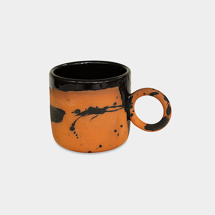 Earl Home's CIRCLE Mug is a hand-thrown white ceramic mug with black brush stroke splatters and a round handle.