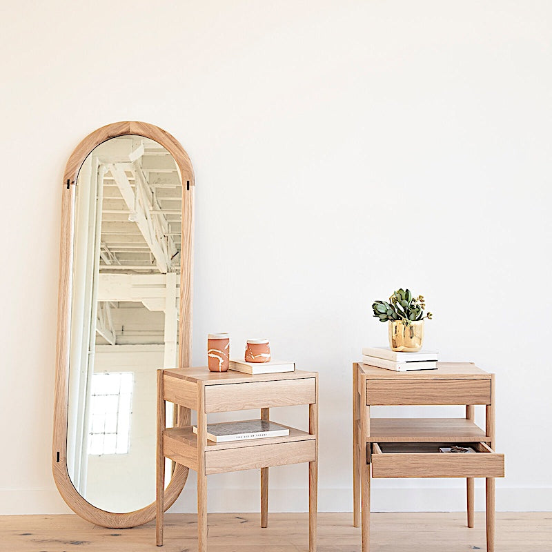 The HAROLD Mirror by Earl Home, a rectangular solid wood piece with metal inlay detailing, exquisitely reflects window light to enhance room brightness.