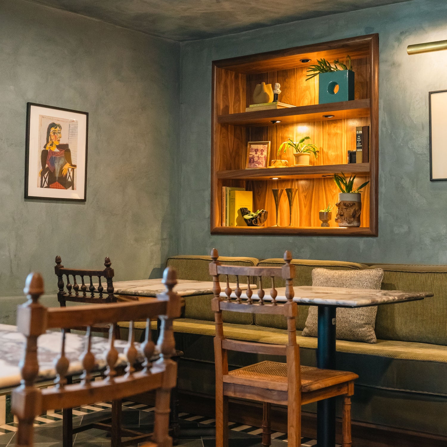 Interior Design by EARL Home at Reunion and Company wine and coffee shop with walnut built in shelves , vintage cane dining chairs, custom marble tables and portola limewash painted walls.