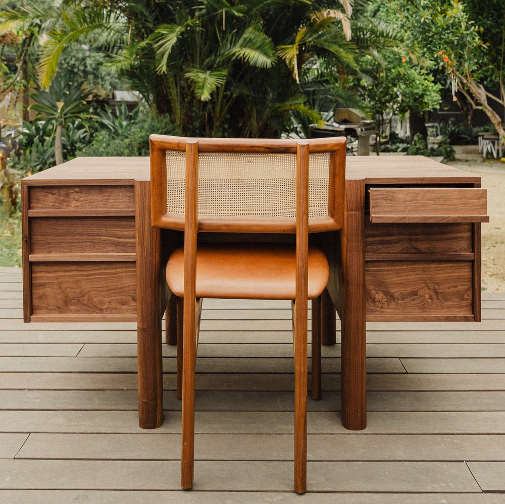 The LAPILO Desk by Earl Home is a handmade wooden piece with minimalist design, reminiscent of a classic tanker desk, featuring four side drawers and straight, sturdy legs.