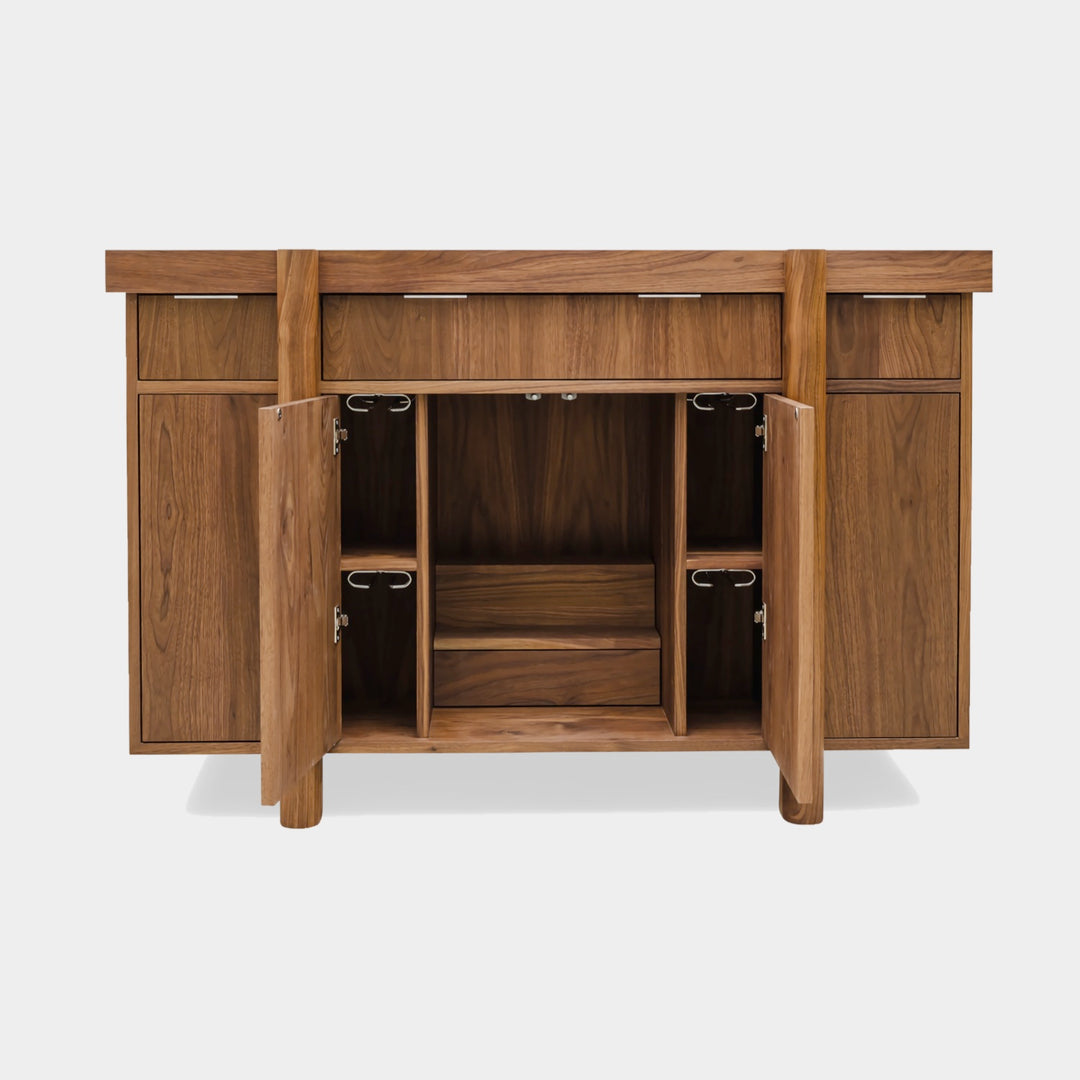 Handmade to order, the LAPILO Bar by Earl Home features open doors and drawers that reveal storage compartments and shelves, making it an ideal choice for a stylish and functional dry bar setup.