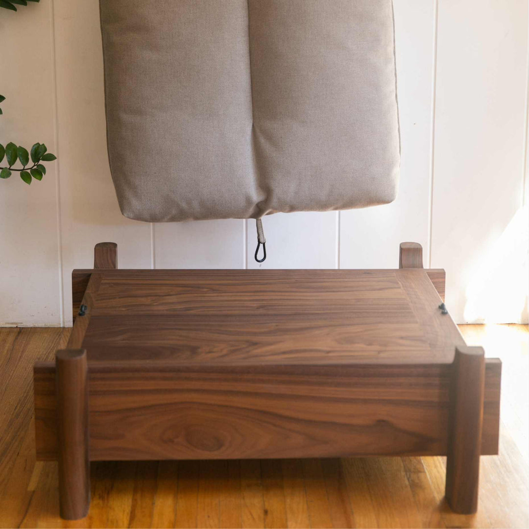 This EARL handmade dog bed has a solid wood base with a hidden drawer, and a custom detachable cushion upholstered in Sunbrella Blend Sand. We offer various fabrics and customers own fabric is encouraged as well. The base can be made in walnut, white oak, or ebonized oak and custom sizing is also available.