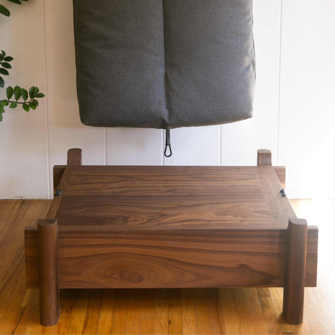 This EARL handmade dog bed has a solid wood base with a hidden drawer, and a custom detachable cushion upholstered in Sunbrella Blend Coal. We offer various fabrics and customers own fabric is encouraged as well. The base can be made in walnut, white oak, or ebonized oak and custom sizing is also available.