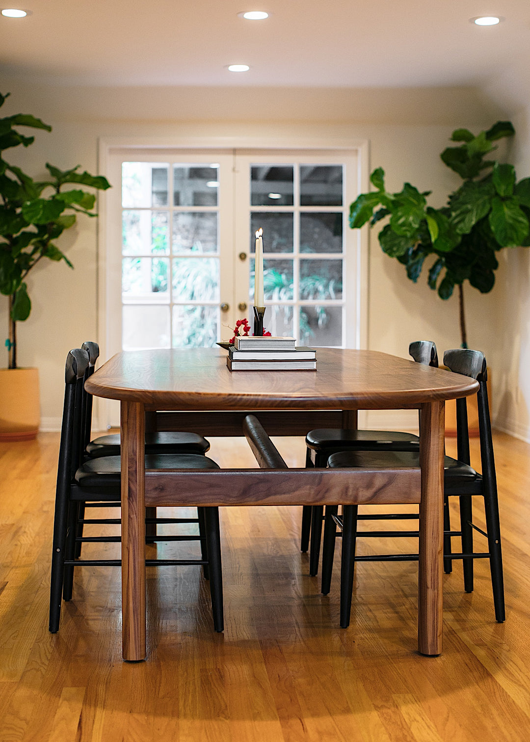 The PALANG Dining Table by Earl Home boasts a robust oval design in rich walnut, supported by four legs and a crossbeam. It comes on a plain white background and offers customizable lengths for perfect fitting in any space.