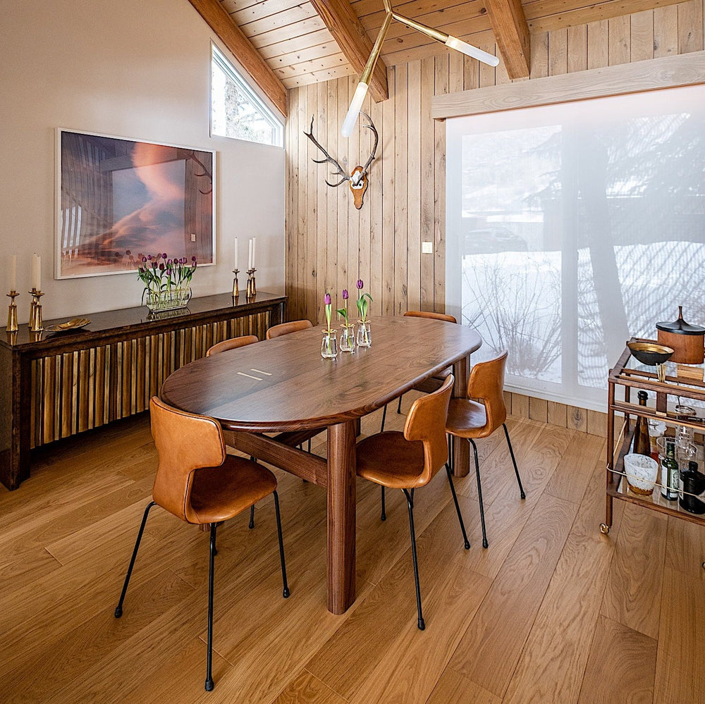 The PALANG Dining Table by Earl Home boasts a robust oval design in rich walnut, supported by four legs and a crossbeam. It comes on a plain white background and offers customizable lengths for perfect fitting in any space.