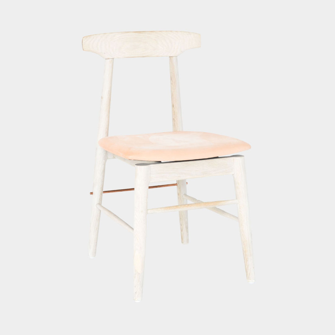 The Earl Home SABLE Dining Chair features a hand-made, bleached oak wooden design with a curved backrest and four legs. Its flat seat exemplifies minimalist elegance, crafted from solid wood for lasting durability. Raw vegtan leather upholstery.