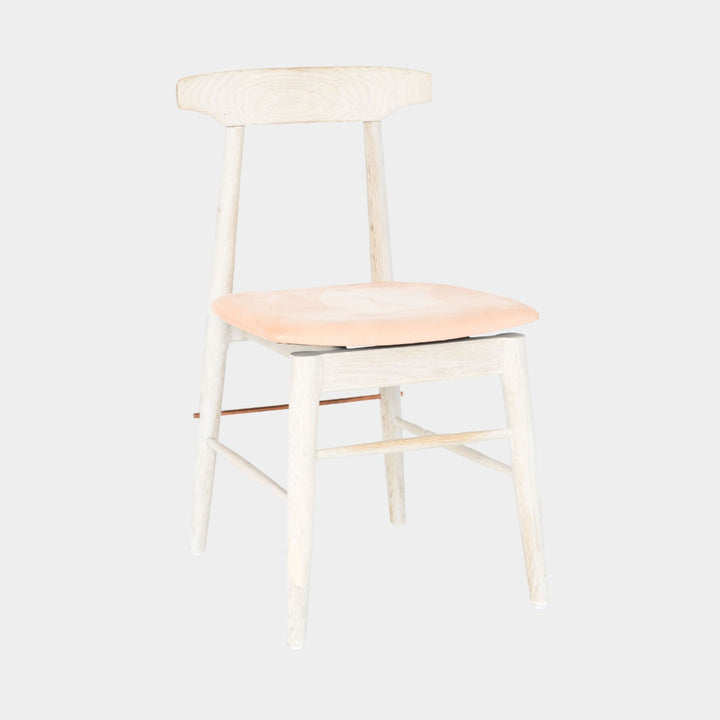 The Earl Home SABLE Dining Chair features a hand-made, bleached oak wooden design with a curved backrest and four legs. Its flat seat exemplifies minimalist elegance, crafted from solid wood for lasting durability. Raw vegtan leather upholstery.