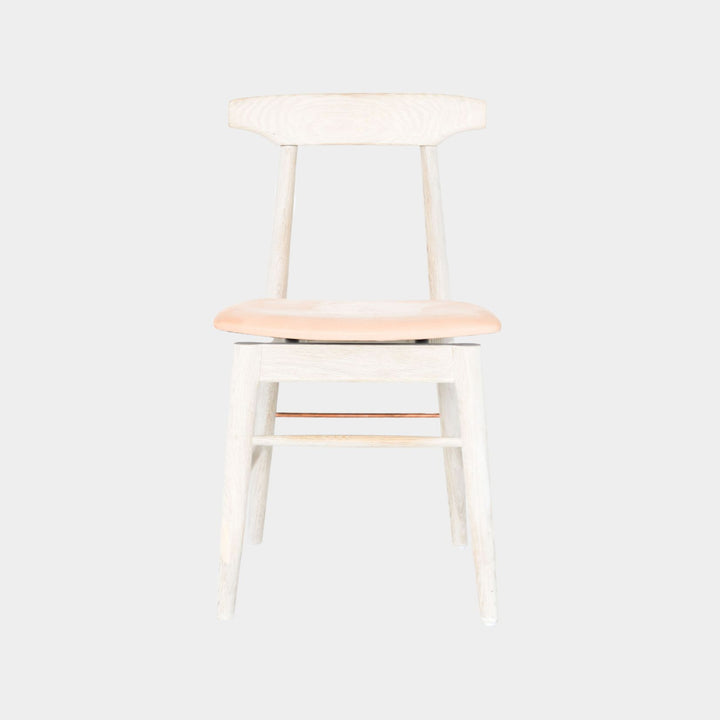 The Earl Home SABLE Dining Chair features a hand-made, bleached oak wooden design with a curved backrest and four legs. Its flat seat exemplifies minimalist elegance, crafted from solid wood for lasting durability. Raw vegtan leather upholstery.