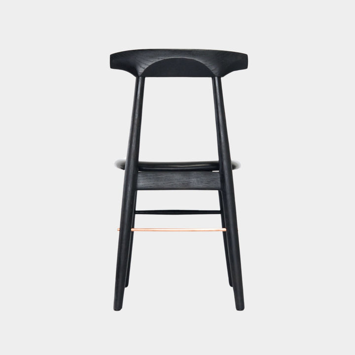 The Earl Home SABLE Dining Chair features a hand-made, ebonized oak wooden design with a curved backrest and four legs. Its flat seat exemplifies minimalist elegance, crafted from solid wood for lasting durability. Black leather upholstery.
