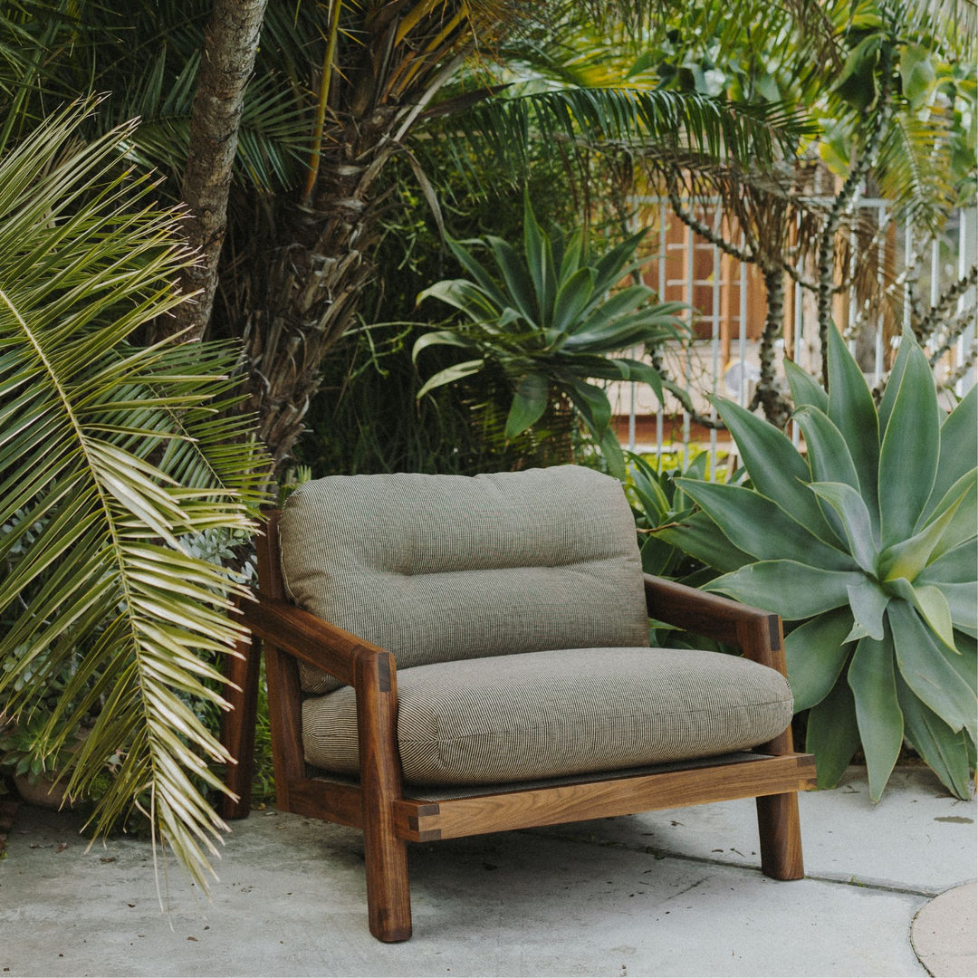 The Earl Home Walnut TAMBU Lounge Chair boasts olive leather upholstery, a sturdy walnut frame, and plush down cushioned seat and backrest gives the ultimate cozy hygge vibe.