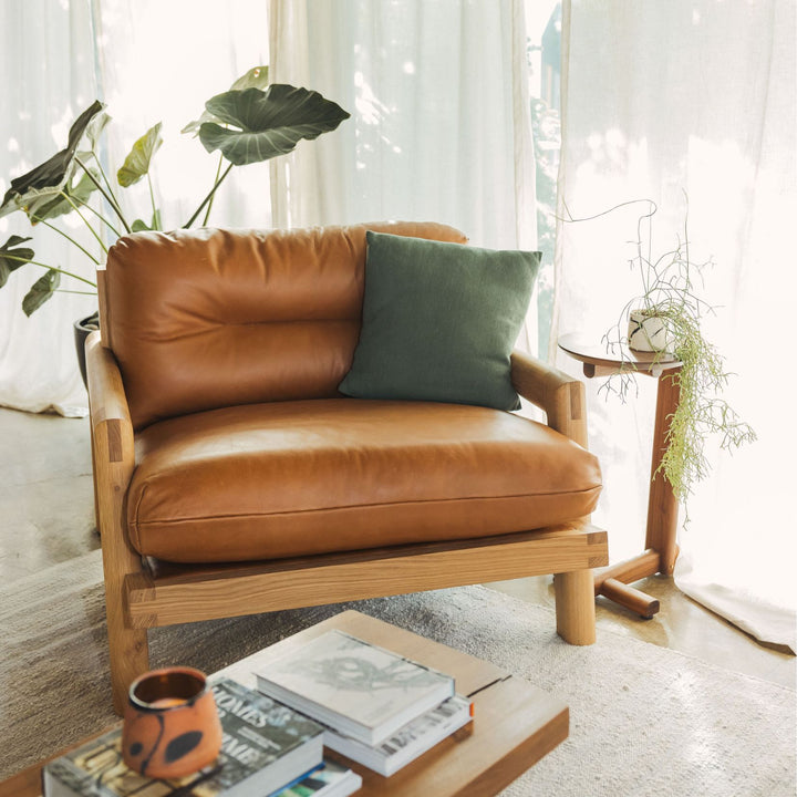 The Earl Home White Oak TAMBU Lounge Chair boasts camel leather upholstery, a sturdy oak frame, and plush down cushioned seat and backrest gives the ultimate cozy hygge vibe.