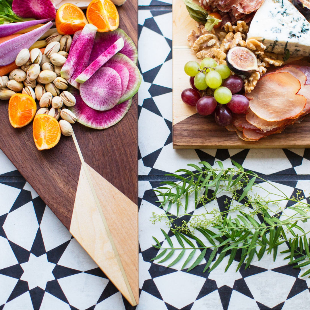 The TRIANGLE Cheese Board by Earl Home is a stylish centerpiece with a triangular design. It is solid walnut and maple featuring a brass spline. Perfect for your cheeseboard or charcuterie spread.