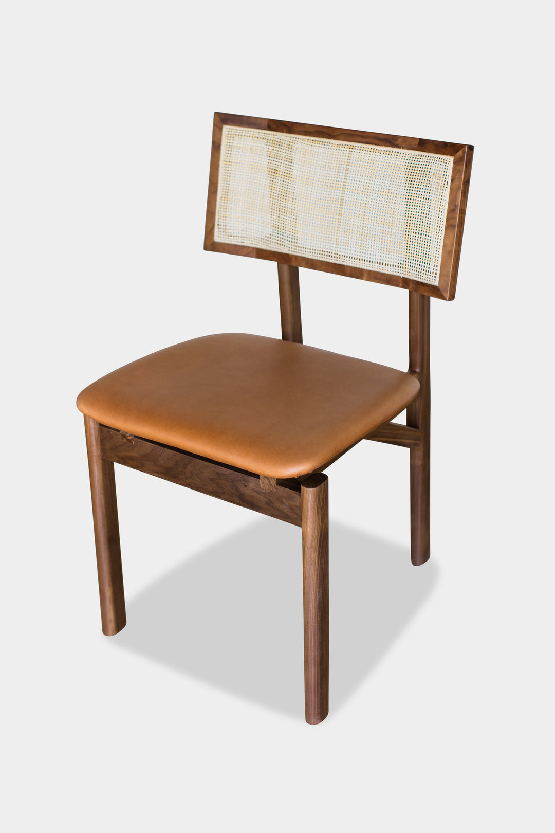 The KUNAI Dining Chair by Earl Home is handcrafted to order, featuring a solid wood frame, brown leather seat, and woven backrest.