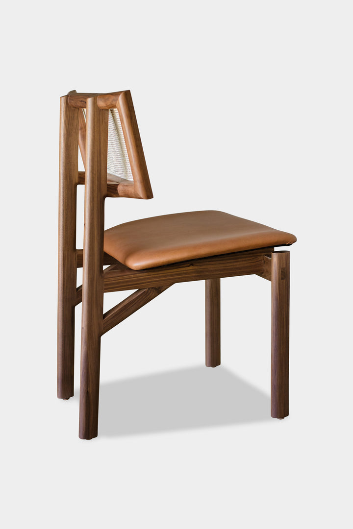 The KUNAI Dining Chair by Earl Home is handcrafted to order, featuring a solid wood frame, brown leather seat, and woven backrest.