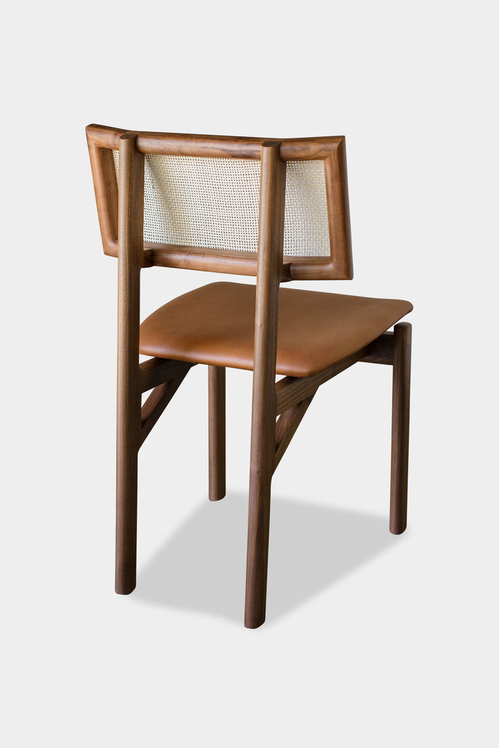 The KUNAI Dining Chair by Earl Home is handcrafted to order, featuring a solid wood frame, brown leather seat, and woven backrest.