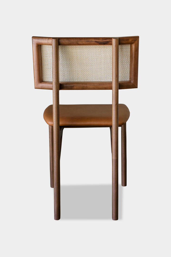 The KUNAI Dining Chair by Earl Home is handcrafted to order, featuring a solid wood frame, brown leather seat, and woven backrest.